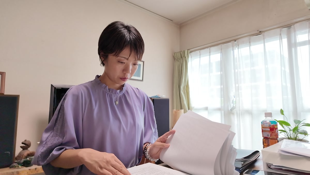 資料を広げて内容を確認する中村理沙
